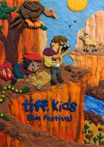 Plasticine illustration of a boy and a girl exploring a canyon. The girl is looking at a map while the boy uses binoculars. There is a snake and vulture in the foreground and a mountain goat in the background. Bright, friendly image meant for kids.
