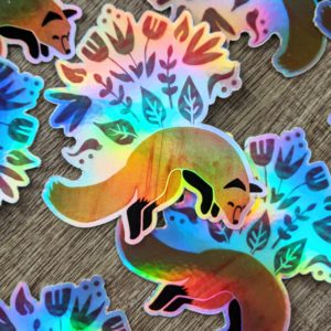 Holographic stickers of a fox leaping. There are flowers and plants above the fox's back in a large arch.